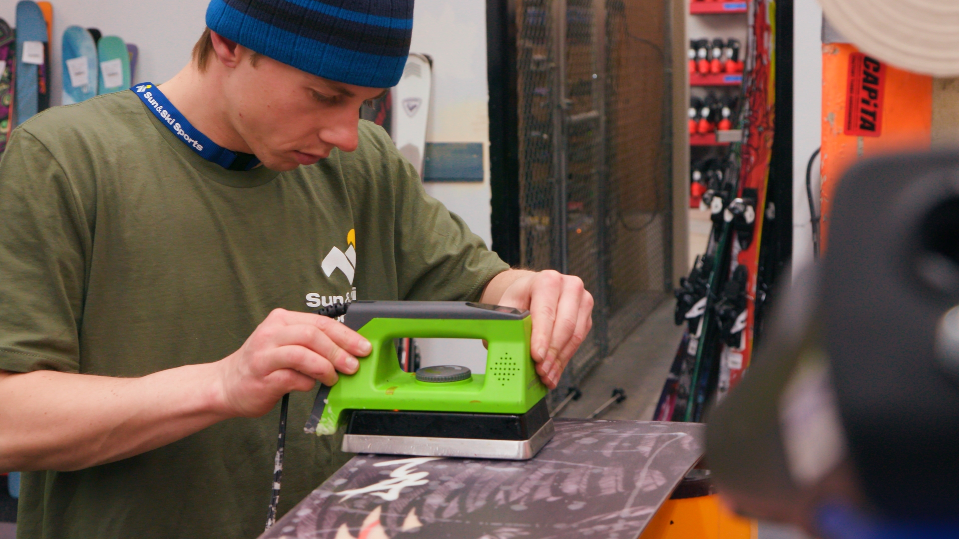 Sun & Ski Sports technician working on snowboard shop services